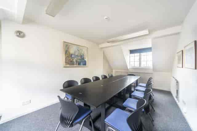 Well-lit Hackney Venues meeting room with black table for strategic planning events.