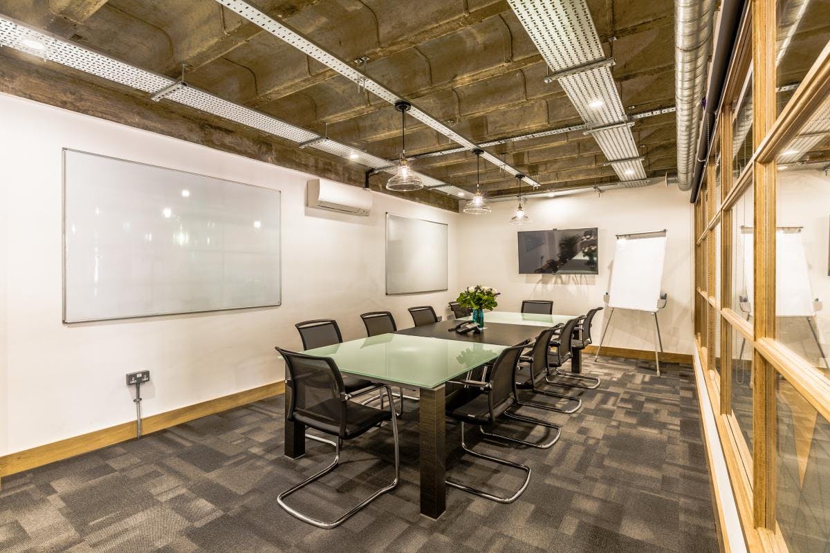 Modern Hackney Venues meeting room with glass table, ideal for collaboration and presentations.