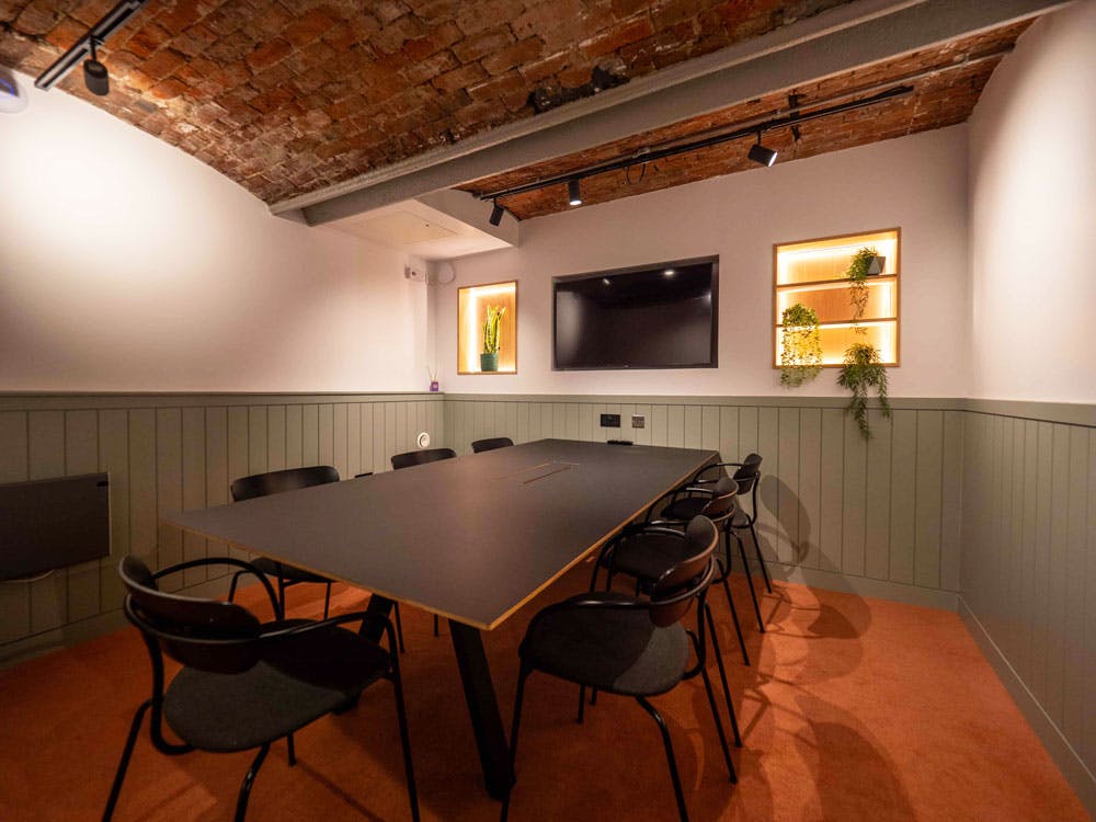 Modern meeting room with black table, ideal for collaborative sessions and presentations.