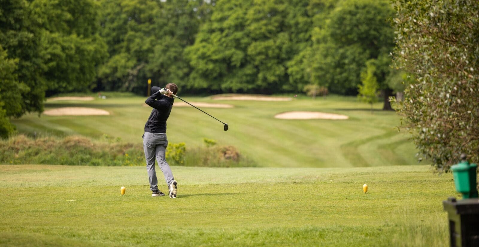 Golfer teeing off at The Ambassadors Club, Arkley Golf Club - ideal for corporate events.