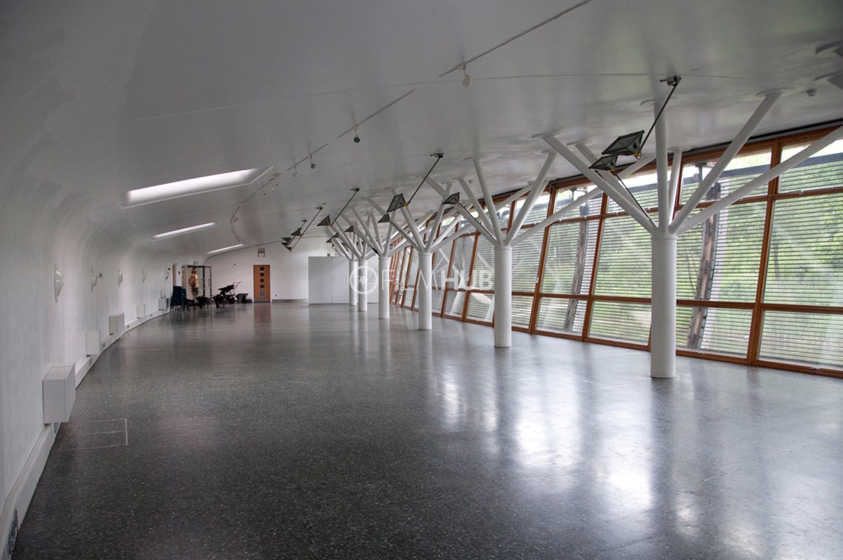 Contemporary glass-walled event venue with natural light for workshops and conferences. - Banner