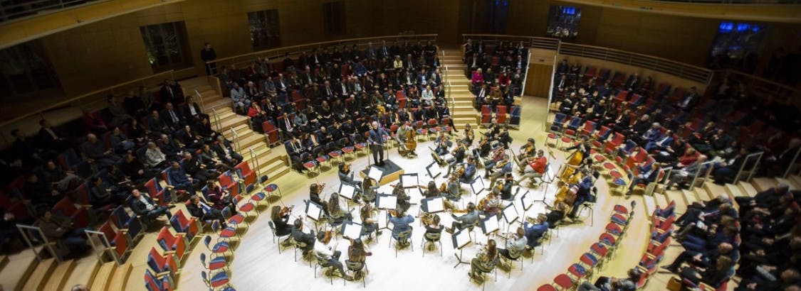 Orchestral performance in modern Pierre Boulez Saal concert hall, showcasing intimate acoustics.