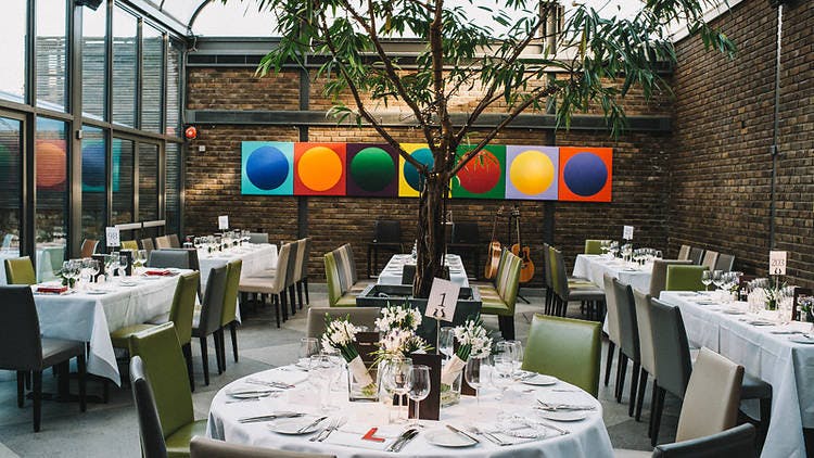 Elegant event space with floral centerpieces and natural light in Frederick's Conservatory.