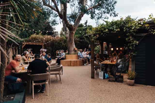 Vibrant outdoor event space with cozy seating and stage at The Lord Nelson Garden.