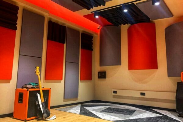 Modern recording studio with orange soundproofing panels for music production workshops. - Banner