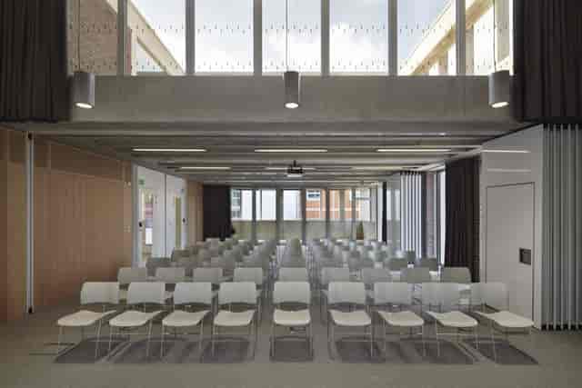 Modern meeting room with white chairs, ideal for presentations and workshops.