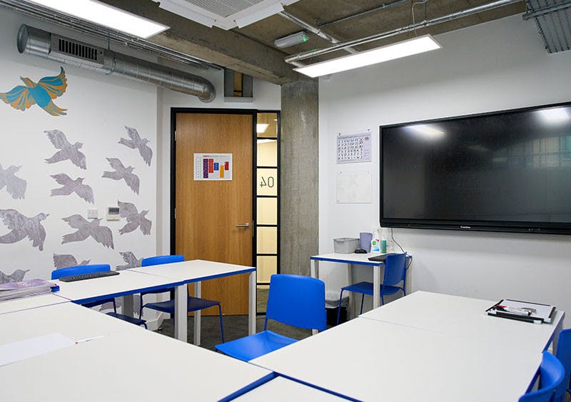 Modern games room with blue chairs, ideal for workshops and meetings.