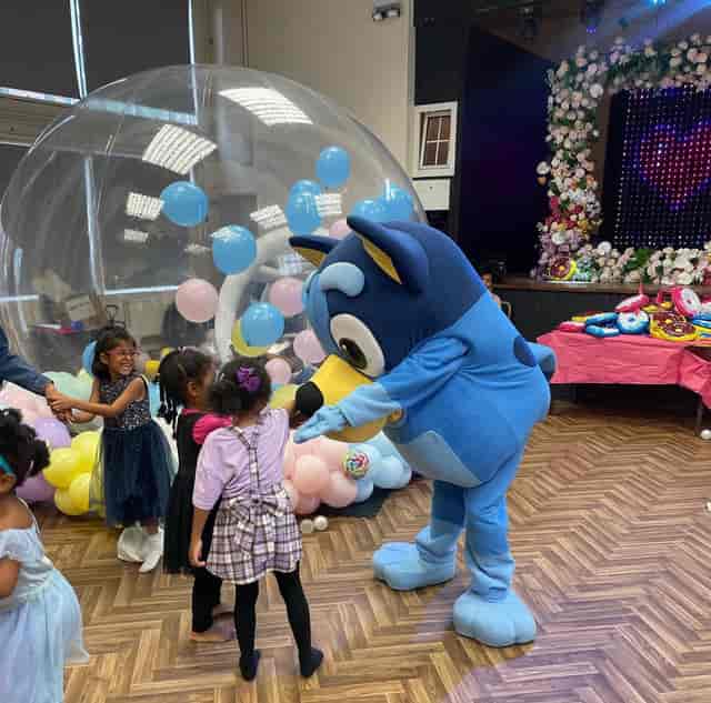 Costumed character entertains children in vibrant Magdalen Hall event space for parties.