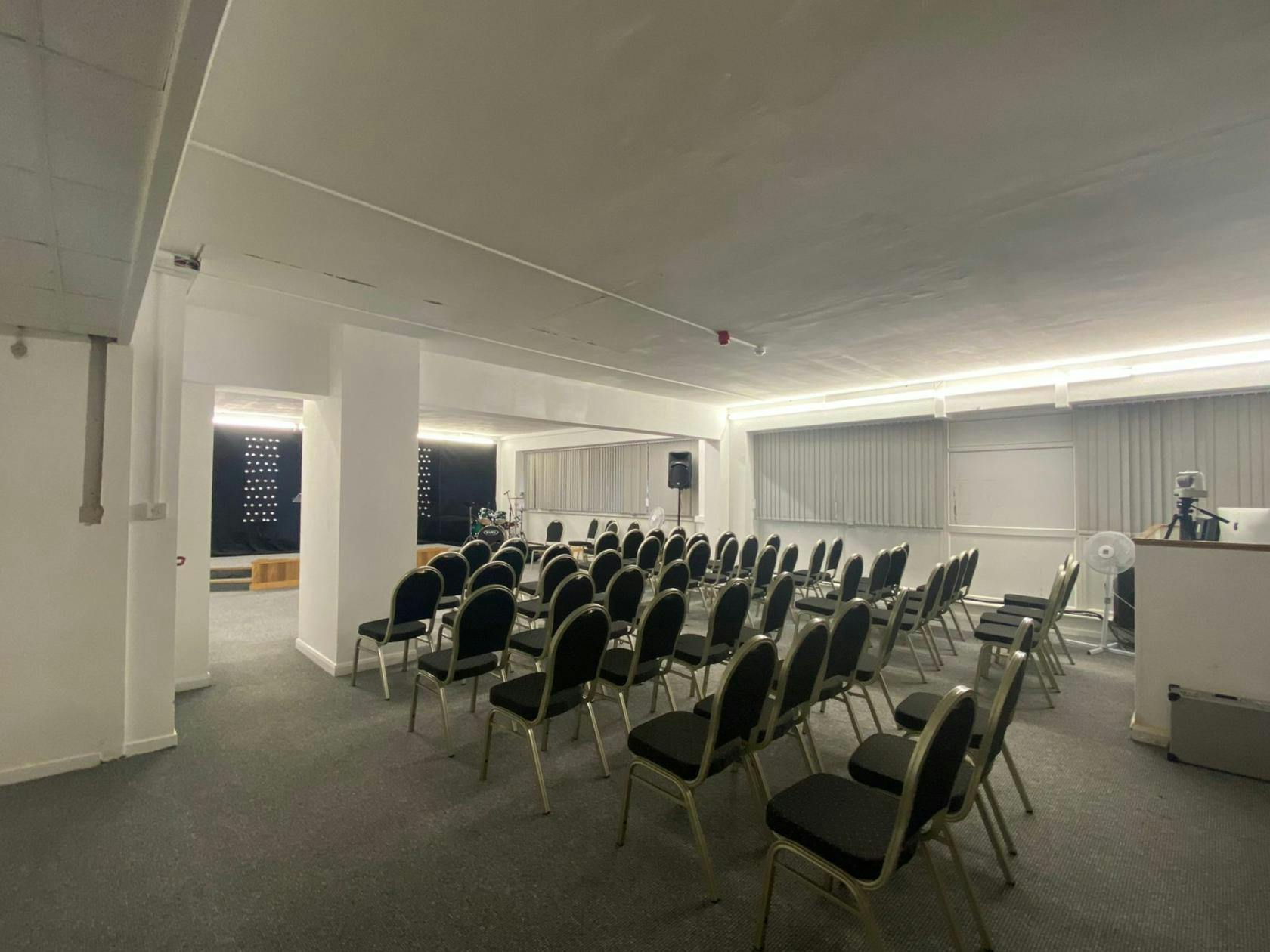 Kingfisher Hall meeting space with black chairs, ideal for corporate events and workshops.