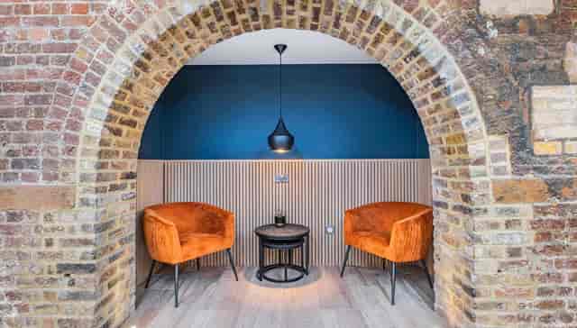 Stylish meeting space with orange chairs in GO Bermondsey for creative discussions.