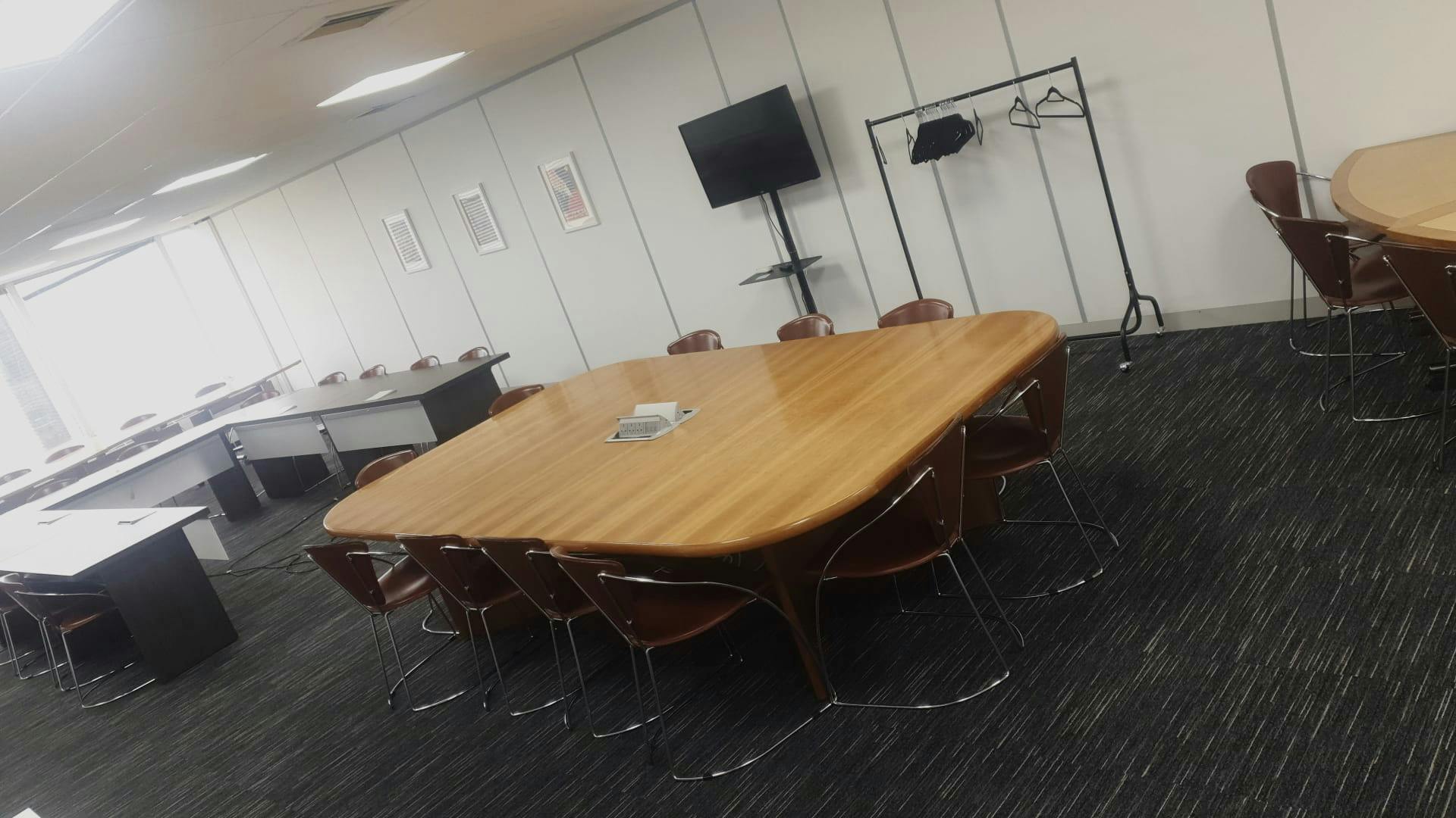 Meeting room with wooden table and TV for presentations at Astral Towers, Crawley.