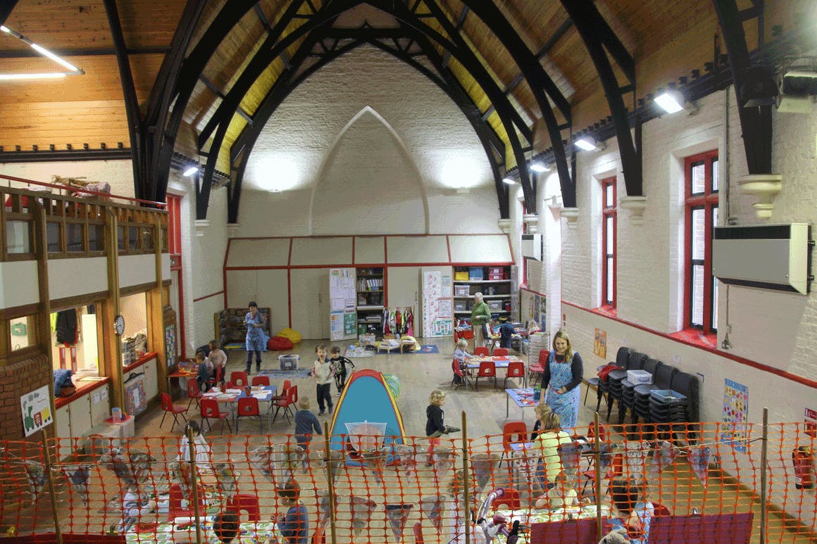 Spacious Teddington Parish Hall with colorful tables for children's events and activities.