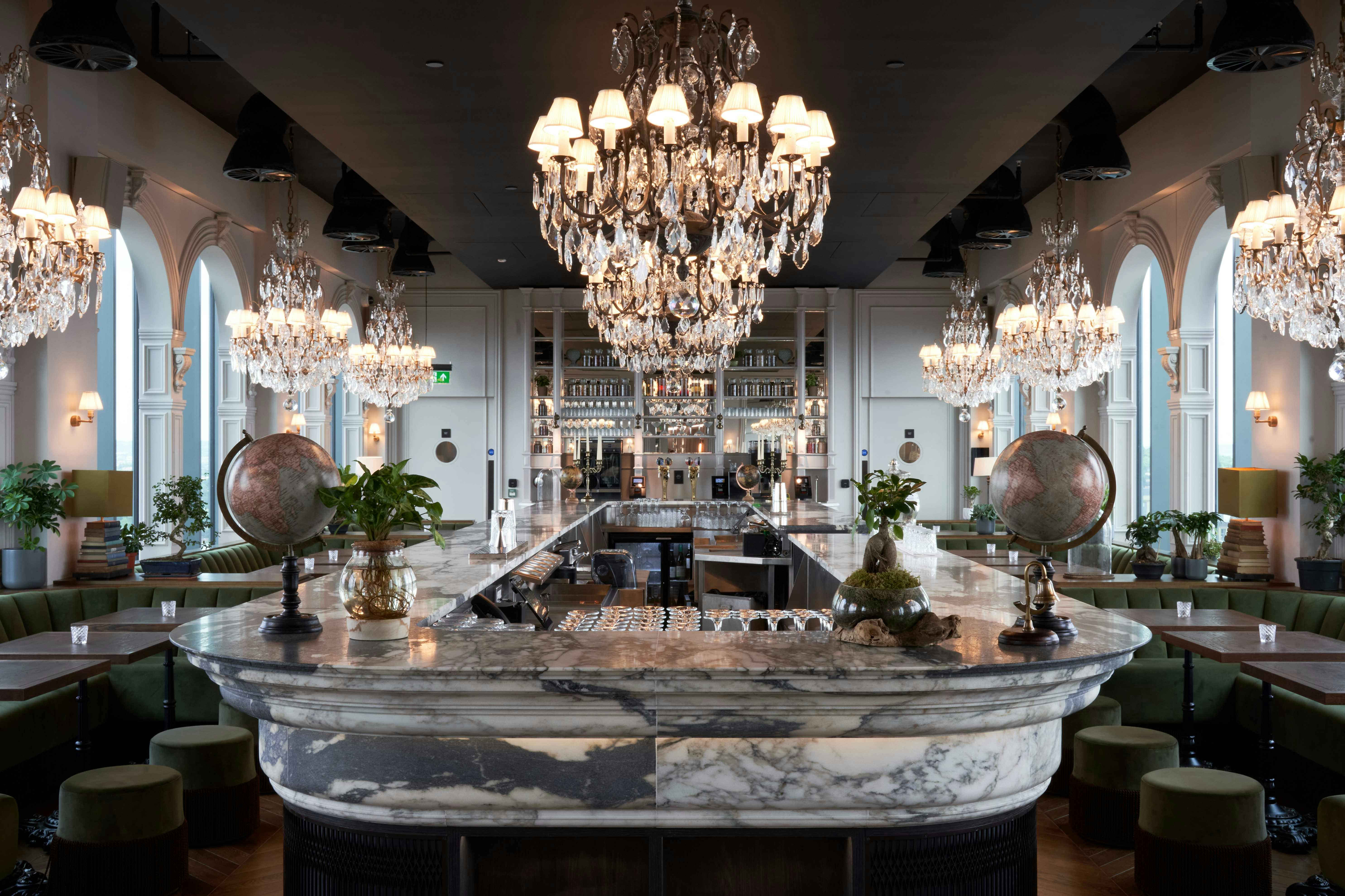 Elegant venue with marble bar and chandeliers for upscale events and receptions.