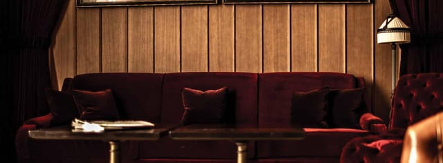 Stylish NoMad Bar lounge with dark wood paneling, ideal for networking events.