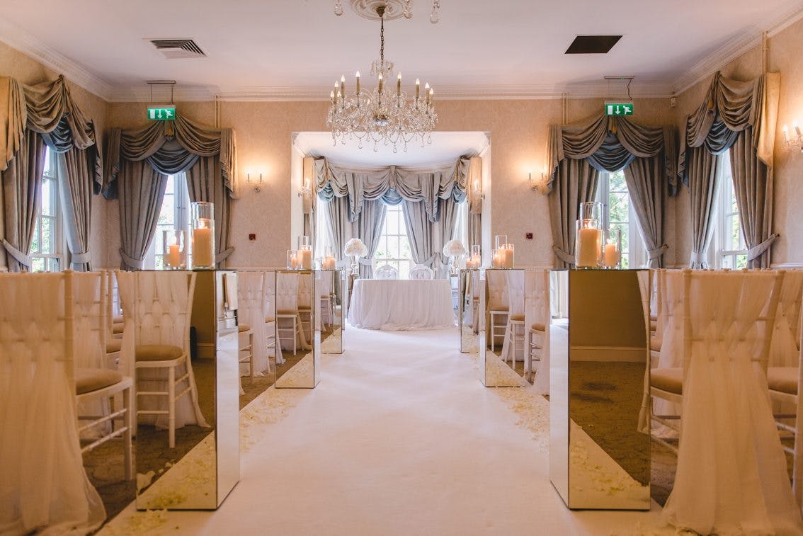 Floral Suite at De Courceys Manor, elegant wedding venue with chandelier and aisle runner.