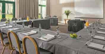 Morgannwg Suite meeting room with U-shaped tables, ideal for professional events and workshops.