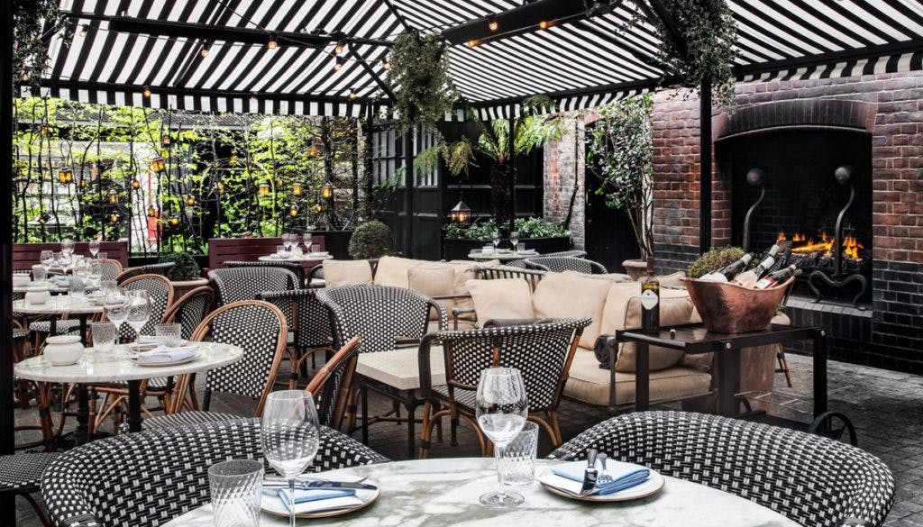 Outdoor terrace with elegant seating and lush greenery for upscale events.