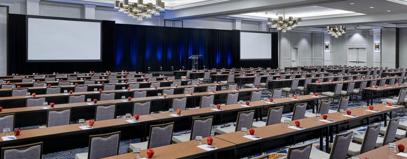 Capitol Ballroom E setup for a conference with classroom-style tables and presentation screens.