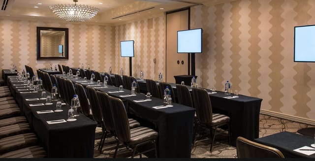 Capital Ballroom meeting room setup with tables, screens for professional events.
