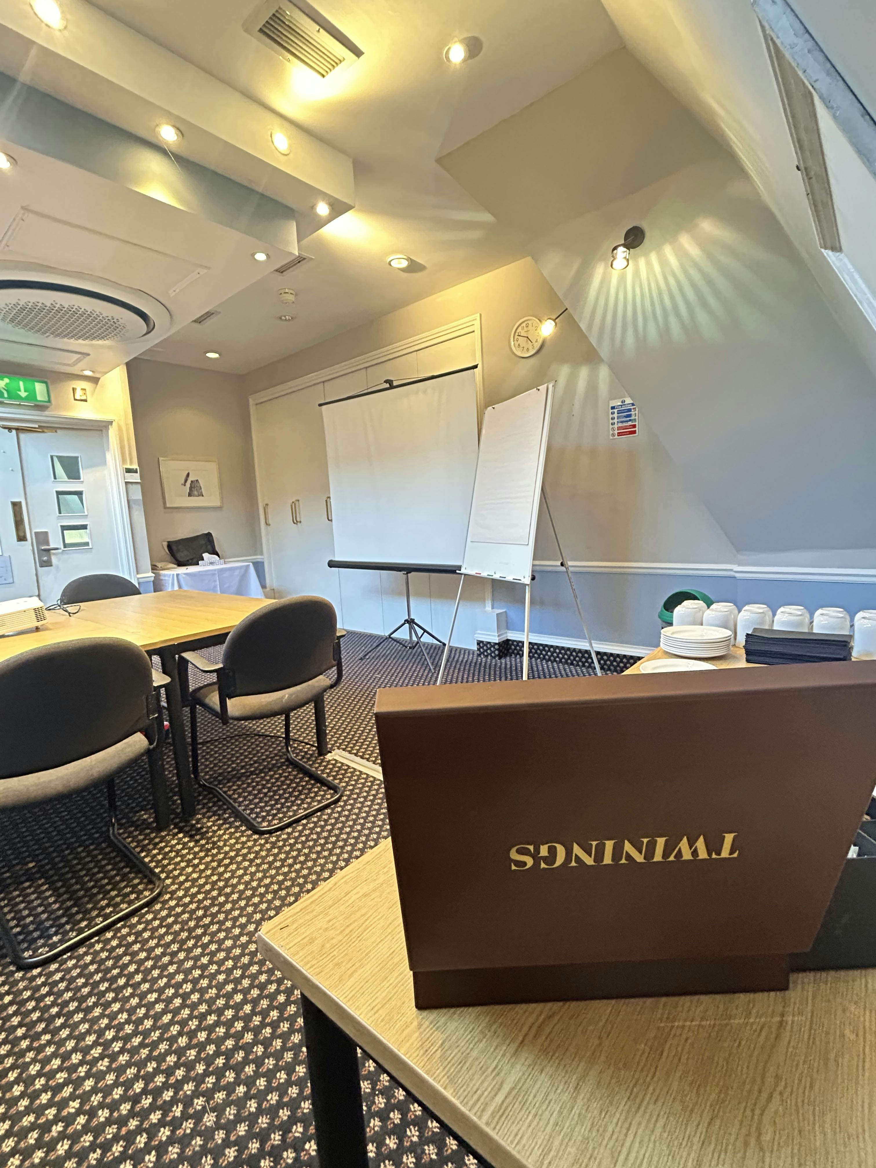Meeting room at Mercure Brighton with projector screen for workshops and strategy sessions.
