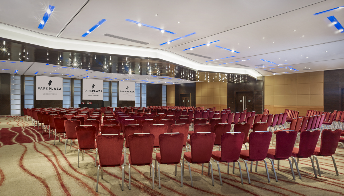 Conference room at Plaza Suites, London with plush red chairs for corporate events. - Banner