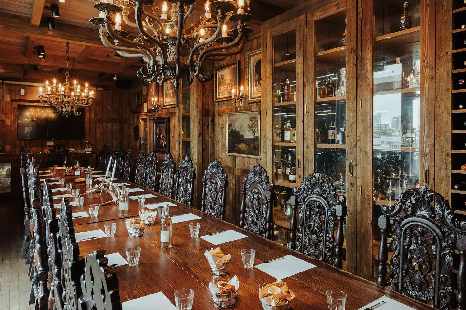 Elegant meeting space at Kings Road Events, featuring a long wooden table and ornate chandeliers.