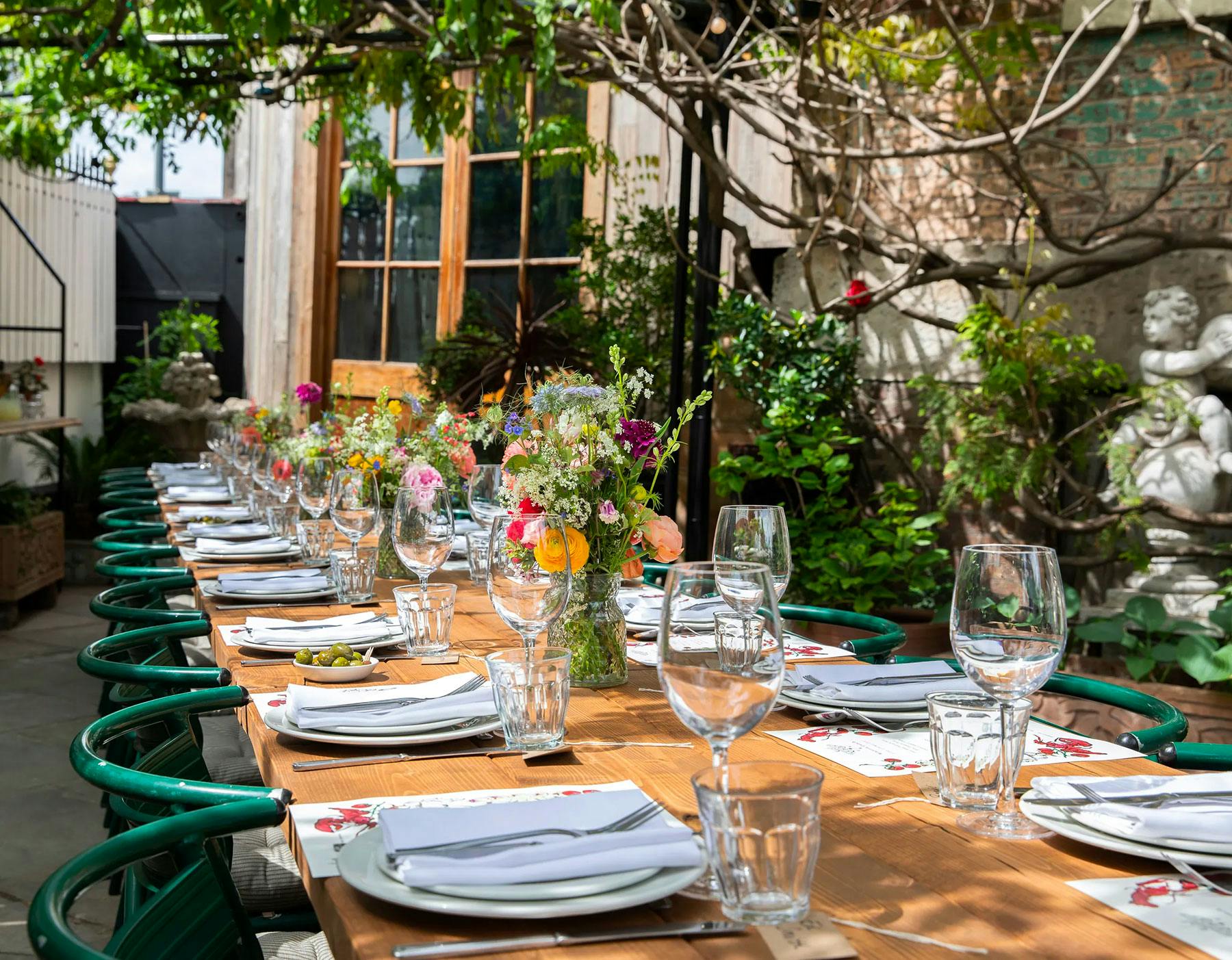 Outdoor dining setup with floral centerpieces at Brunswick House for events.