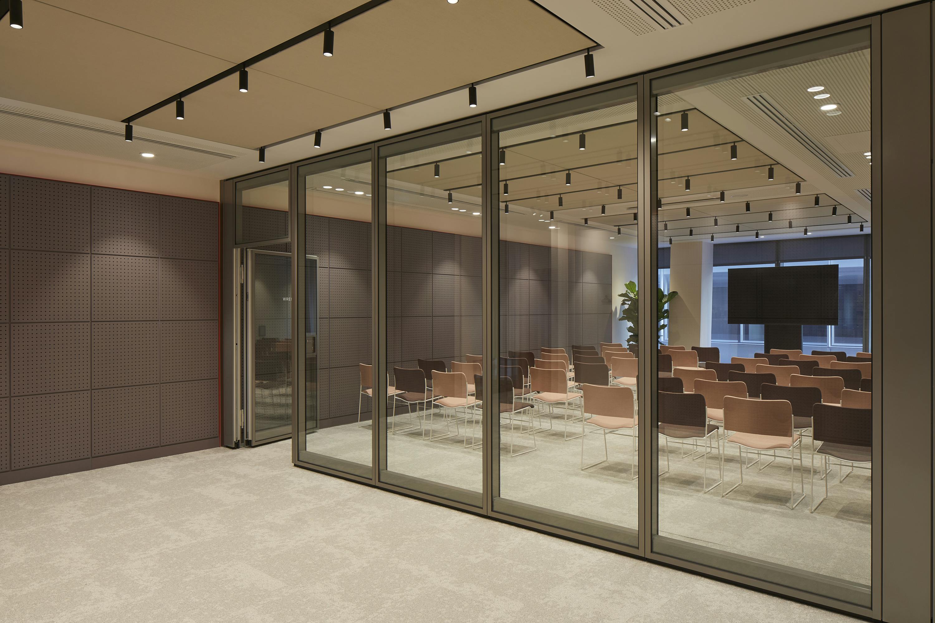 Modern meeting room with glass walls, ideal for corporate events and workshops.