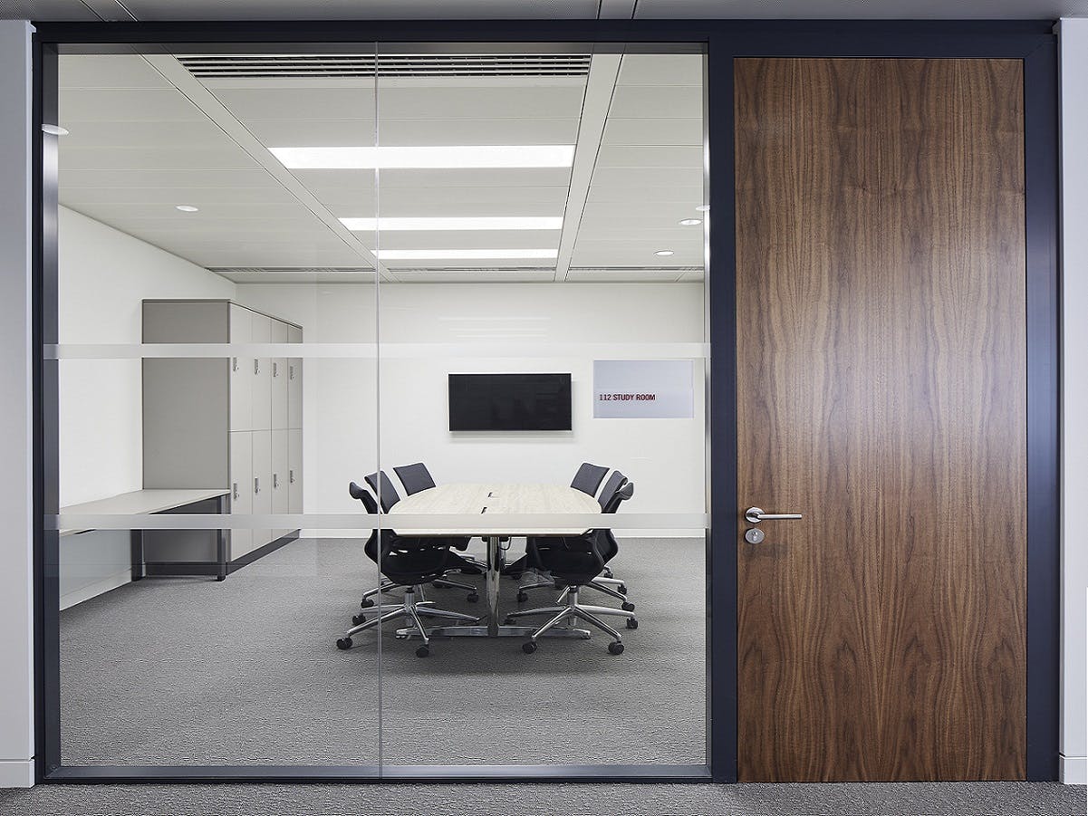 Modern meeting room with large table and glass walls at London Conference Centre.