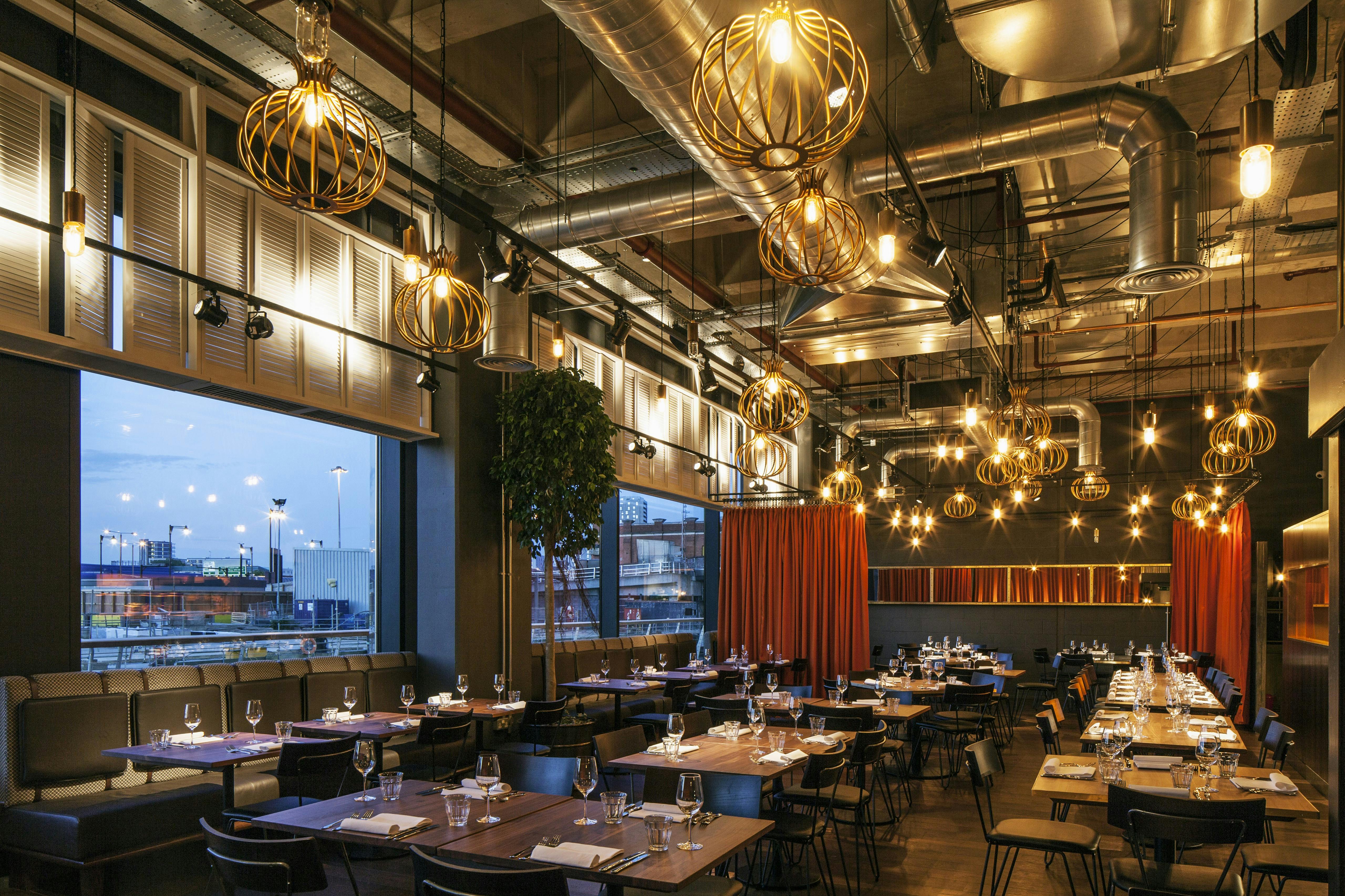 Modern restaurant interior with pendant lighting, ideal for events and gatherings.