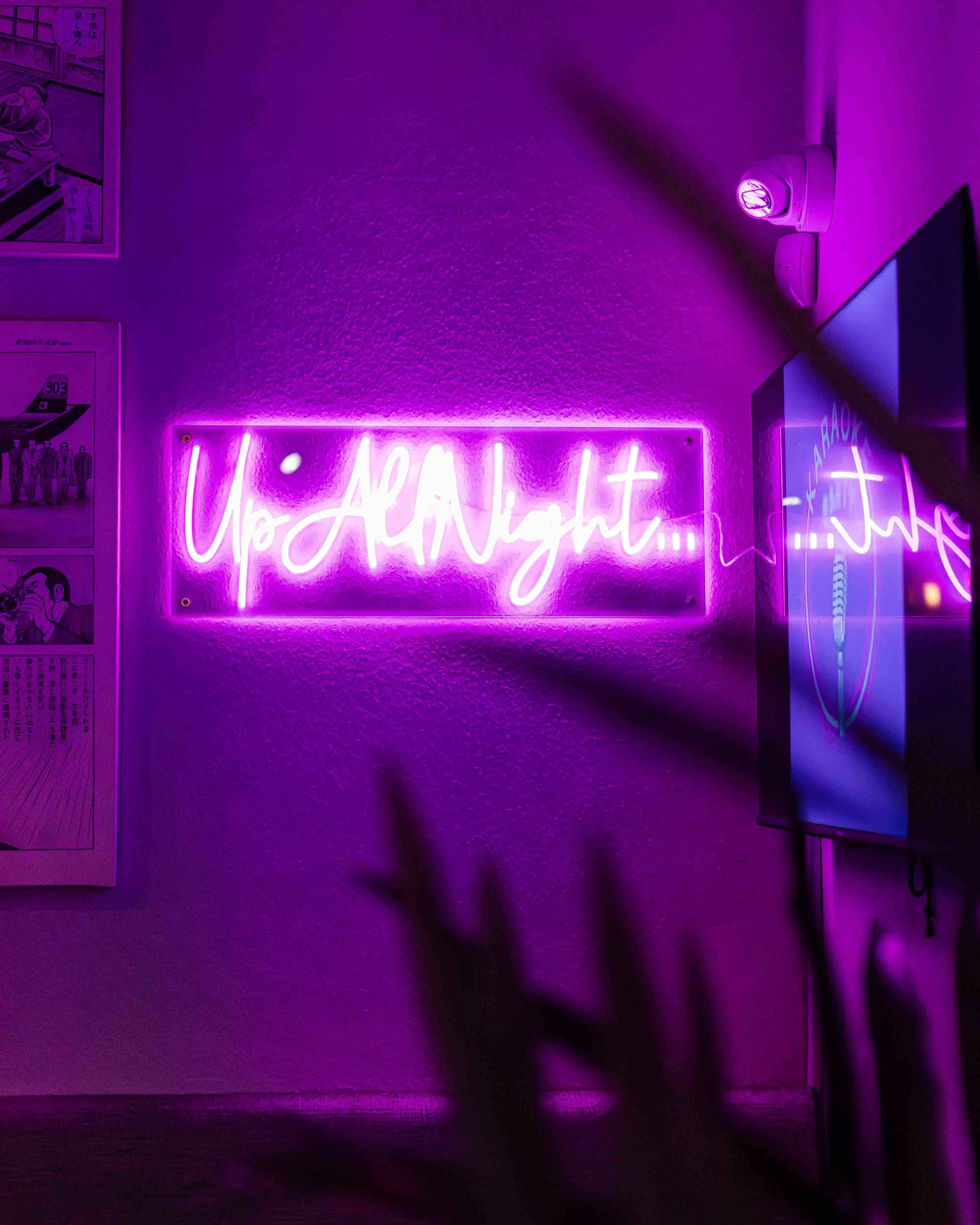 "Vibrant neon 'Up All Night' sign at Bath Karaoke for lively late-night events."
