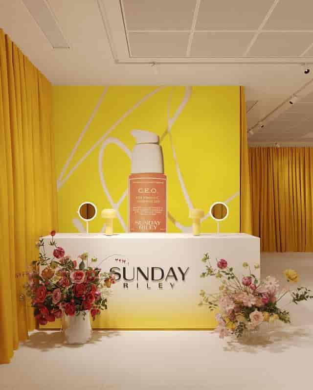 Vibrant product launch event space with yellow backdrop and floral accents.