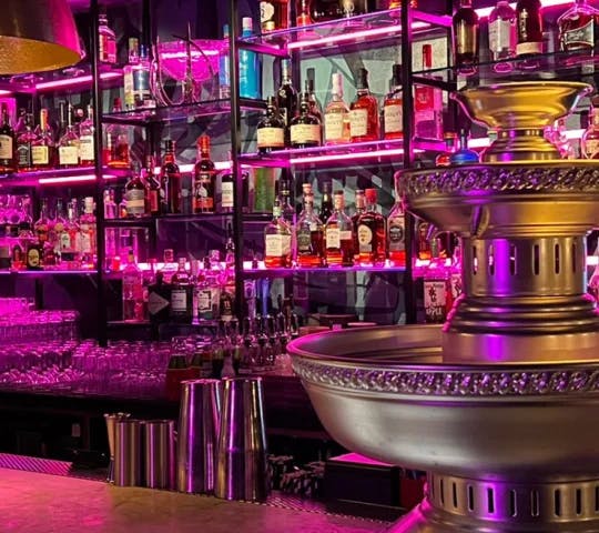 Vibrant bar at The Cottons Club with fountain, ideal for cocktail receptions.