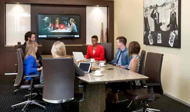 Modern meeting room at Servcorp Canary Wharf with professionals collaborating.