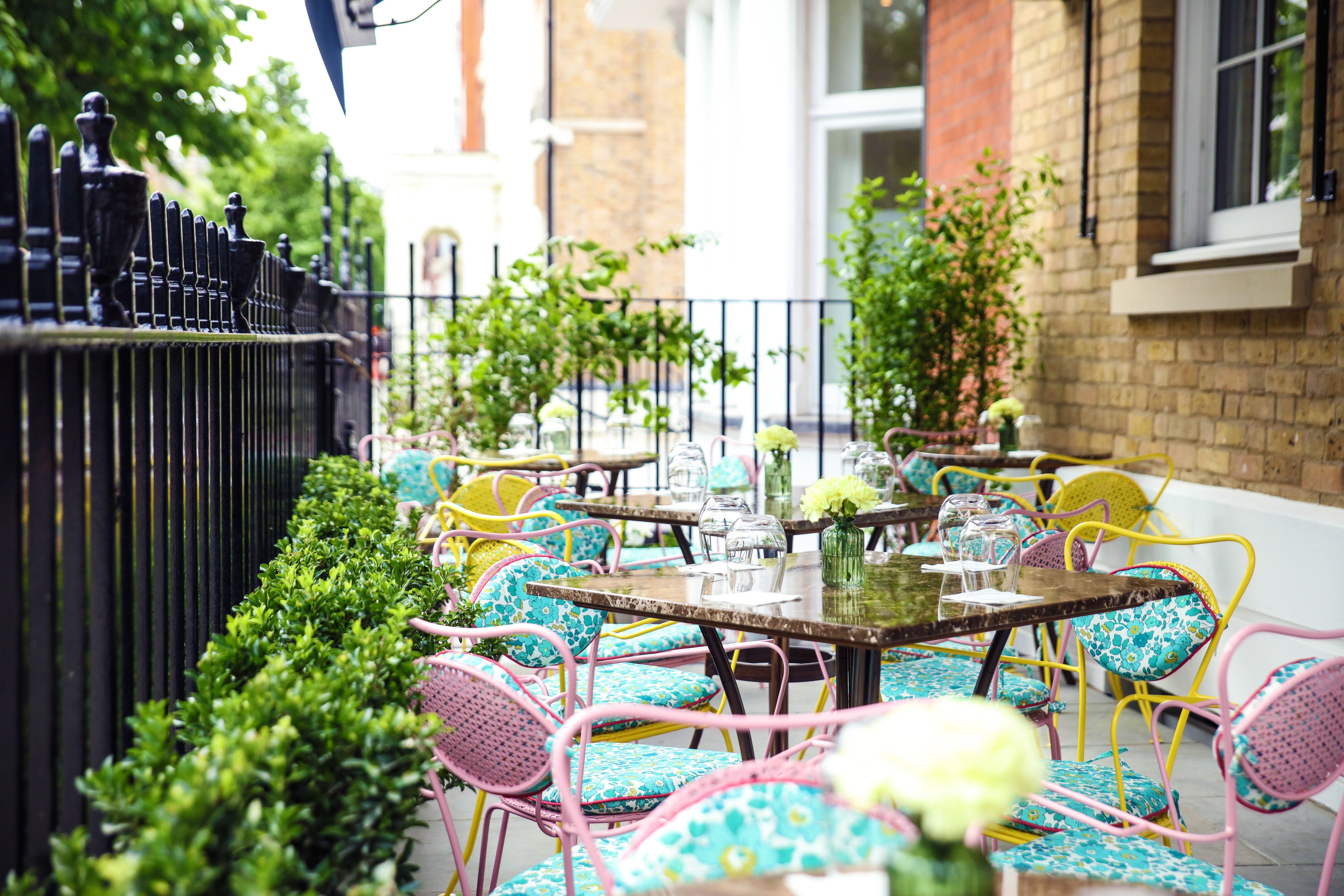 Charming outdoor terrace with vibrant seating for casual meetings and networking events. - Banner