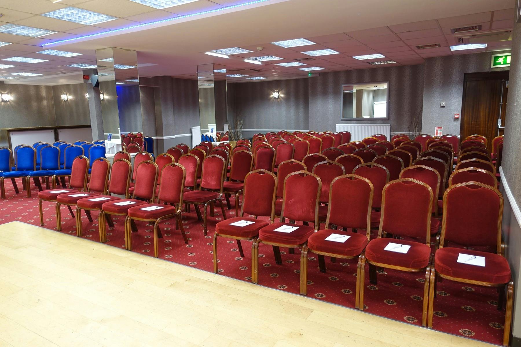 Conference setup with red chairs in spacious Clarendon Hotel meeting room.