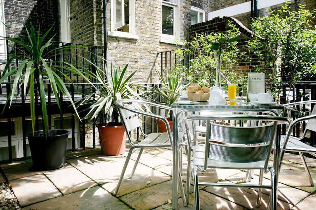 Charming outdoor gardens at The Clarendon Hotel for networking events and casual meetings. - Banner