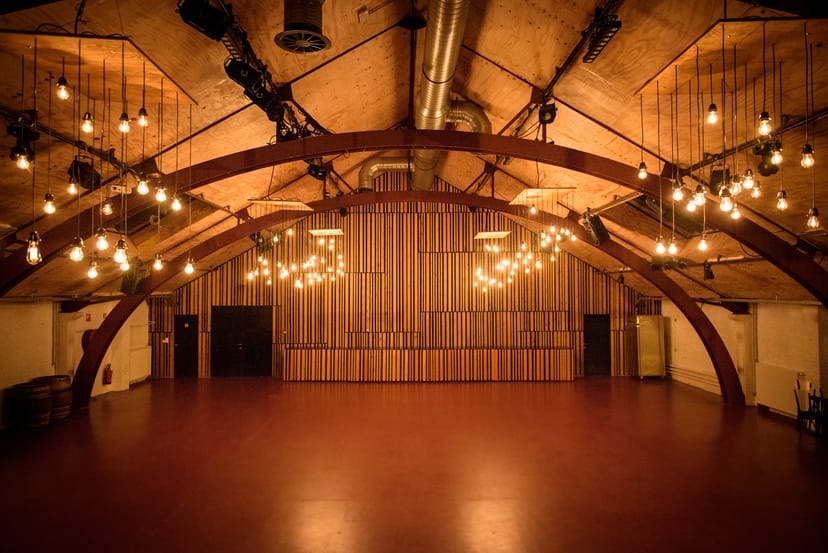 Versatile event space with exposed beams, ideal for gatherings and celebrations.