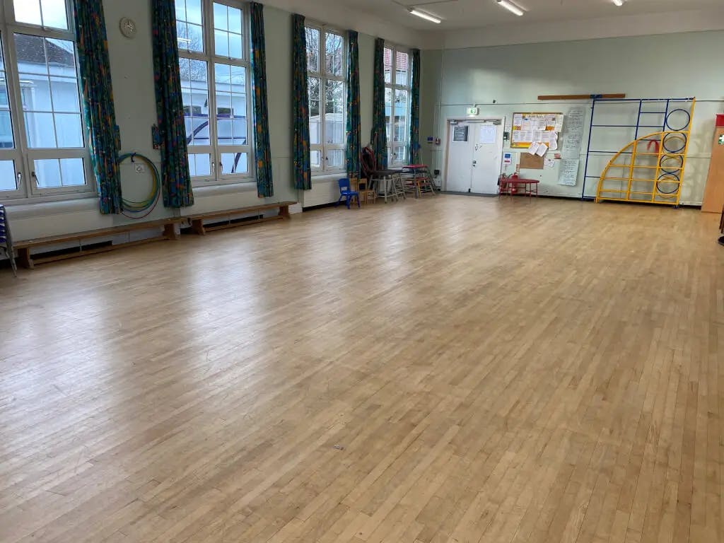 Spacious event space with wooden flooring, ideal for meetings and workshops.