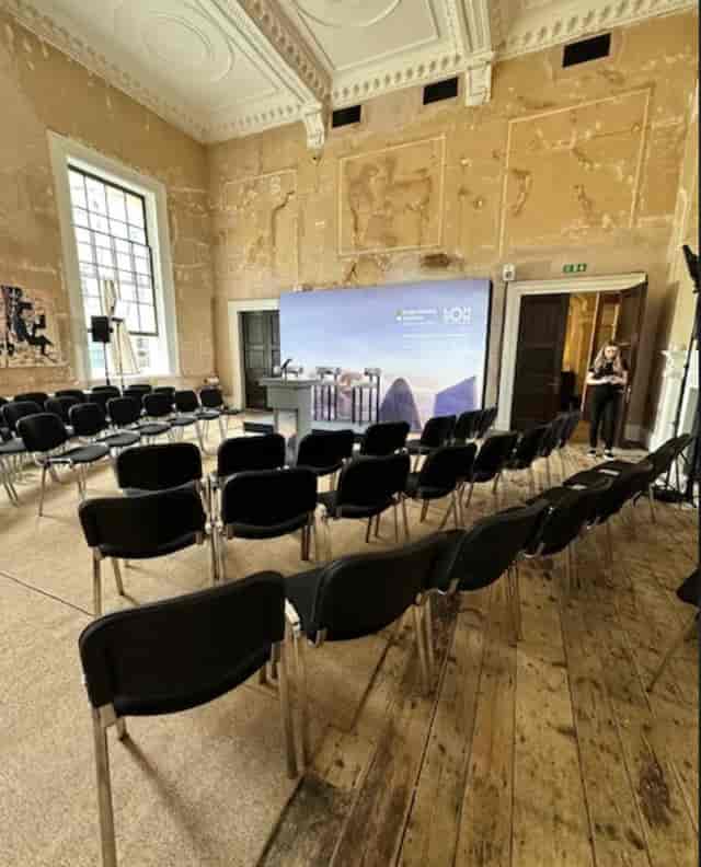 Event space with black chairs and podium for presentations at Knotel Workclub.