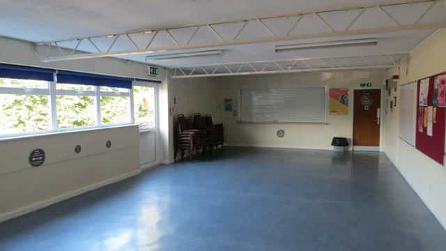 Versatile meeting room with natural light, ideal for workshops and gatherings.