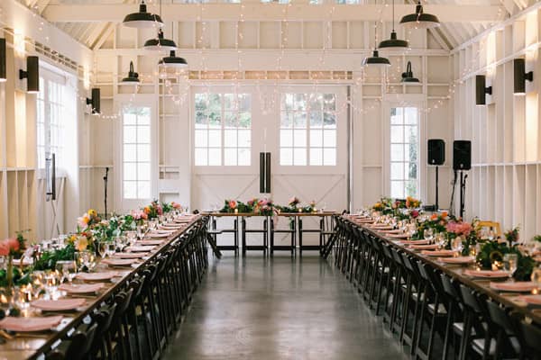 Elegant barn event space with floral centerpieces, perfect for gatherings and celebrations.