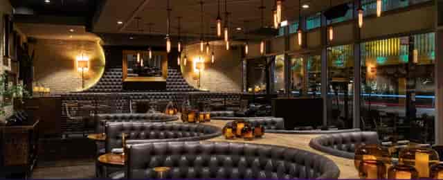 Semi-private oval bar with plush seating, ideal for networking events and private dinners.