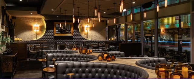 Semi-private oval bar with plush seating, ideal for networking events and private dinners.