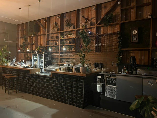 Stylish bar with rustic wood backdrop, ideal for intimate gatherings and networking events.