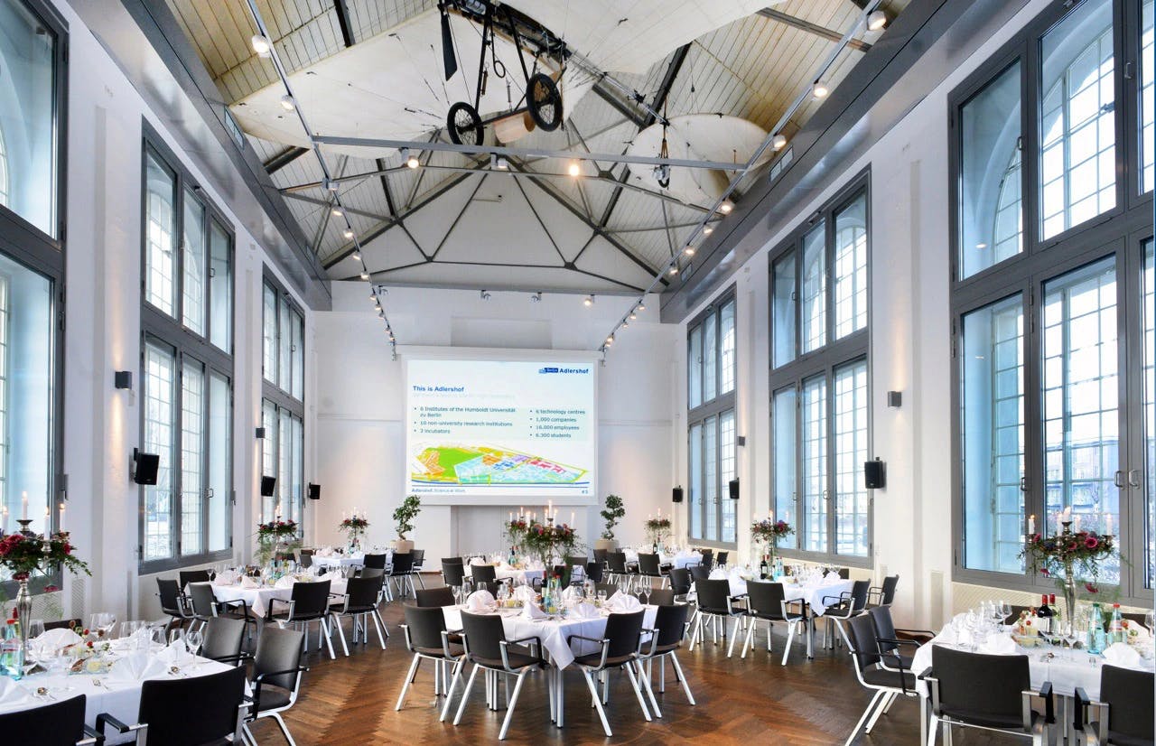 Elegant function room with round tables, ideal for corporate events and formal dinners.