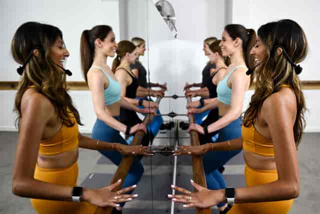 Dynamic fitness class in Barrecore Chiswick with mirrors, ideal for wellness events.