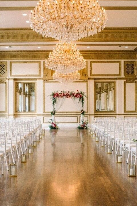 King Edward wedding venue with elegant chandelier and floral arch in Alexandria Ballrooms.