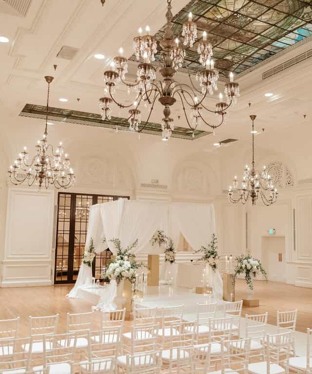 Elegant Palm Court altar with floral arrangements, perfect for weddings and upscale events.