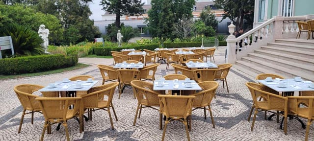 Elegant outdoor networking setup at Valle Flor, Pestana Palace with lush greenery.